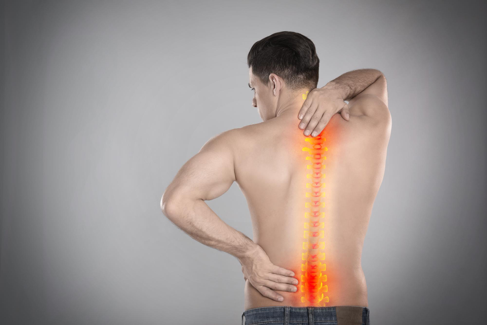 man-suffering-from-pain-spine-grey-background
